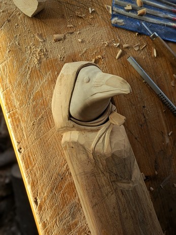 The draft as now a more defined face fort the crow, eyes, littles hairs on the beak. There is a scarf arround its neck.